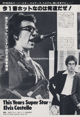 Vintage magazine article / photo feature for Elvis Costello featuring Elvis on stage with glasses and a microphone, with text in Japanese and English.