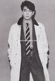 ryuichi sakamoto of YMO wearing a coat, tie, and vest against a plain background